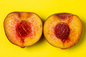Naklejka na ściany i meble Peaches on a yellow background. Peach cut in half. Healthy diet.