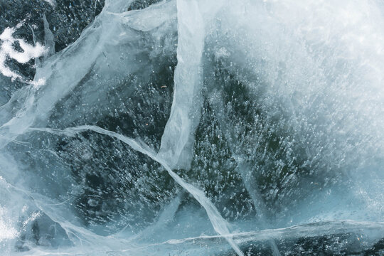 thin cracks of ice in a transparent lake © Марина Верина