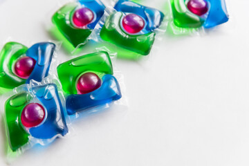 washing pods on white background, close up, abstract color background.liquid detergent,capsules with colored gel.3 in 1 laundry detergent pod. Economic and environment friendly for clothes washing