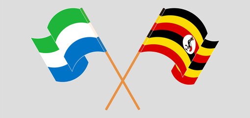 Crossed and waving flags of Sierra Leone and Uganda