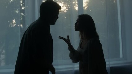 Silhouettes of man and woman shouting at each other, couple quarreling in the evening at home husband and wife screaming. Scandal and crisis in family. Domestic violence, abuse. - Powered by Adobe