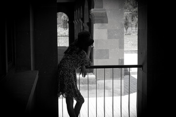 beautiful girl looking out balcony back view