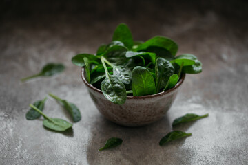 Leaves of fresh baby spinach in a Bowl. Dark organic green leaves. Healthy vegan food lifestyle...
