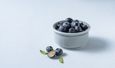 sweet fresh blueberries in a bowl  on a blue background. Macro and close up. Front view and copy space