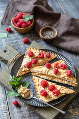 Summer sweet dessert sandwich breakfast. Tasty toasted with peanut butter and raspberry on a rustic wooden table.