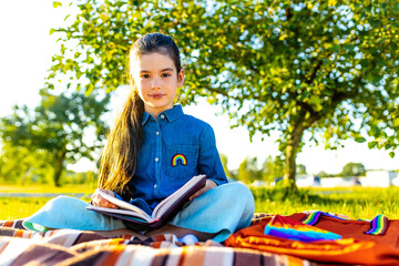 Smiling indian student girl wearing school backpack and blue t-shirt in park