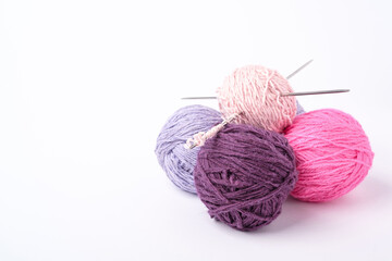 Colorful yarn balls and knitting needles on white background