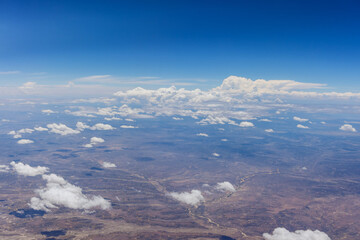Fototapeta premium Overview of fluffy clouds in desert from an airplane, New Mexico