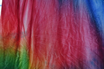 Abstract painted background. Multi-colored pattern in the shibori technique on a thin knitted fabric. Multi-color texture. batik.Textile shibori