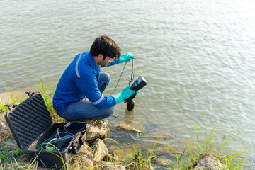 Technician use the Professional Water Testing equipment to measure the water quality at the public canal. Water quality monitoring concept.