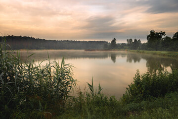 Beautiful sunrise at lake surrounded by forest in Krasnobród, Roztocze, Poland.