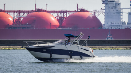 MOTORBOAT AND LNG TANKER - A recreational boat goes out to sea 