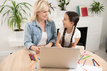 Mother and little daughter doing homework online. Distance learning online education.