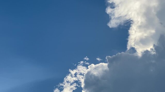 White clouds in a deep blue sky. Wide angle full circule motion, in a slow-fast-slow pan left.