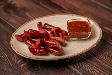 Smoked sausages cut into pieces lie on a plate