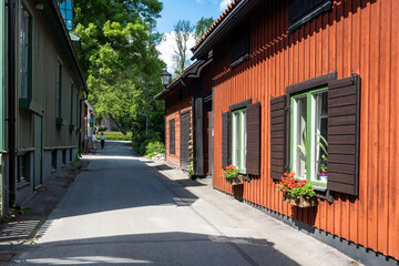 Fototapeta na wymiar The central walking street of the city of Sigtuna. Old wooden buildings built at the past centuries. Landmarks of the ancient capital of Sweden. Colorful painted wooden houses along the narrow street.