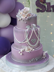 Closeup shot of a purple birthday cake decorated with roses