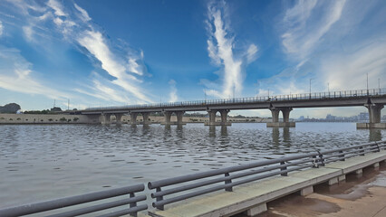 Closeup shot of a bridge over a river and a beautiful skyline with linear clouds