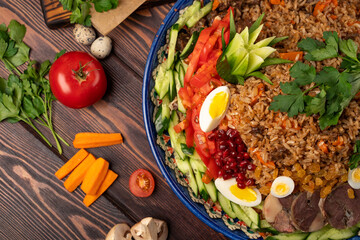 Ready Uzbek pilaf in a large plate, garnished with vegetables