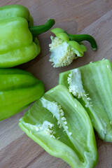 Bell peppers, cut into halves and whole. Fresh vegetables for cooking lie on a wooden background. Vertical photo.