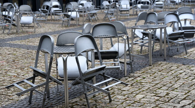 Menschenleere Stühle und Tische einer Außengastronomie	