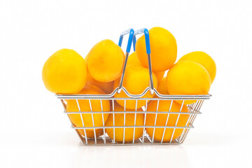 Ripe apricots in a grocery basket from a supermarket on a white background