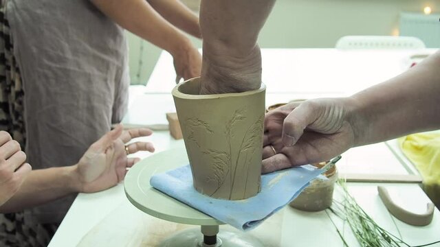 Woman hand potter making clay cup in pottery workshop studio. Process of creating ceramic mug. Handmade, hobby art and handicraft concept.
