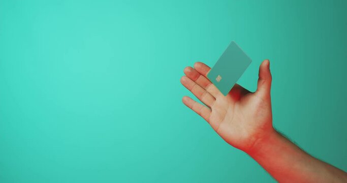 Male hand and levitating template mockup bank credit card with online service isolated on green background