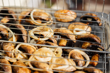 champignon mushrooms are cooked on a grill. shish kebab on the grill. Grilled meat skewers, shish...