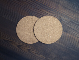Fototapeta na wymiar Photo of two blank cork beer coasters on wooden background. Responsive design mockup. Flat lay.