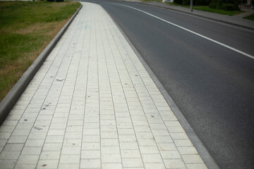 Obraz premium White tile sidewalk. Walking path in the city.