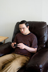 young adult with down syndrome playing video games in couch