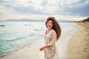 Fototapeta na wymiar Portrait of cheerful woman laughing at beach shore