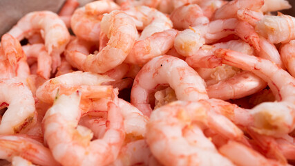 Fantastic close up of peeled fresh shrimps in a metallic bucket ready for serving.
Seafood and food preparation concept.