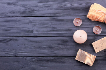 Vertical shot spa soap with candles and towel on wooden desk.