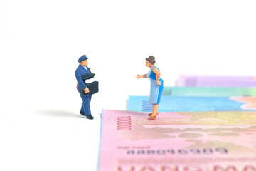 Miniature people toys conceptual photography. COD (Cash on delivery) service. Postman courier with cash money paper, isolated white background.