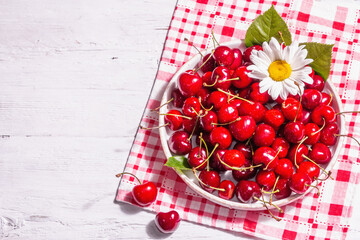 Naklejka na ściany i meble Fresh ripe sweet cherries in a bowl with droplets of water