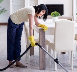 Senior old woman tired after vacuum cleaning house