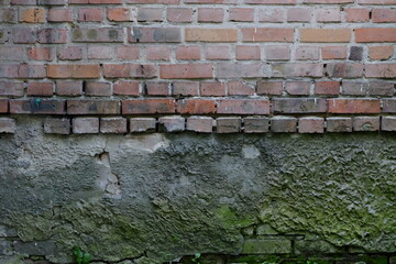 aged brick wall texture with green concrete at the bottom