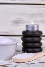 Spoon with salt and black stones with burning candle.