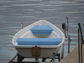 White Rowboat with Blue Seats on Boat Lift - Lake Life