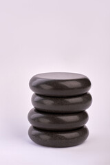 Fototapeta na wymiar Vertical shot stack of black stones on white background.
