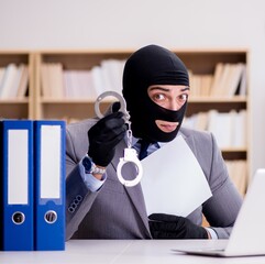 Criminal businessman with balaclava in office