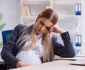 Pregnant woman employee in the office