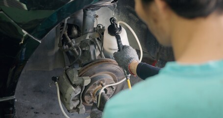 Auto mechanic replacing brake fluid on a vehicle, technician bleed air out of disc brake system in garage workshop, Car repair in a car service