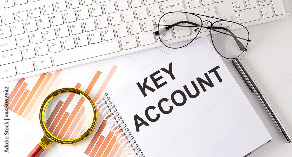 Poster key account text written on a notebook with keyboard, chart,and glasses