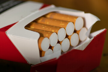 Close-up photographed open brown filter cigarette box as a threat to people's health
