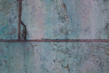 Green copper patina on a stone wall