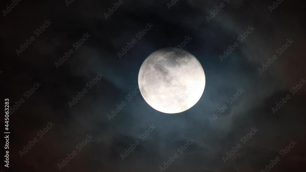 Wall mural clouds drifting across the sky. full moon in the background
