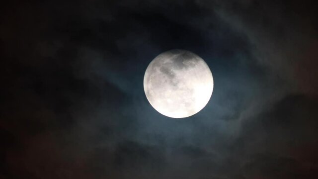 Clouds drifting across the sky. Full moon in the background